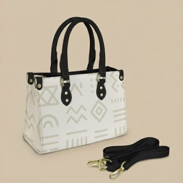 Sac à main blanc Maïa Muto L’Amana Épure avec motifs géométriques gris, anses noires et bandoulière.