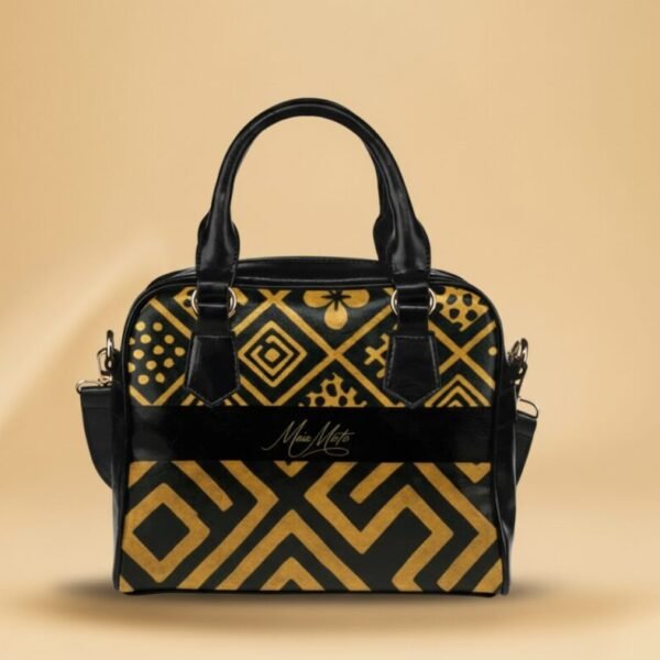 ac à main noir et or Maïa Muto L'Amana Éclipse avec motifs géométriques complexes et logo central.
