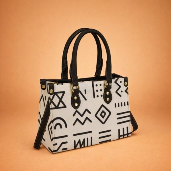 Sac à main noir luxe Maïa Muto Odyssée Signature avec grande calligraphie dorée et anses noires.